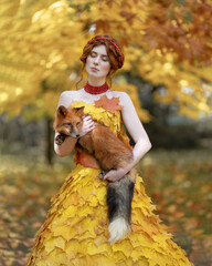 Autumn portrait of a red-haired girl with a fox