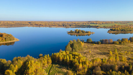 Autumn forest and lake. View from the top. Aerial Photo of an Island in Lake on Sunny Autumn Day.