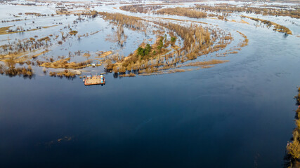 Aerial view of dredge replenish sand in river. Canal is being dredged by excavator. Top view of dredging boat crane.