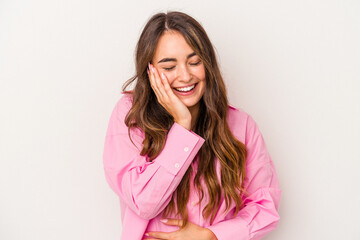 Young caucasian woman isolated on white background laughs happily and has fun keeping hands on...
