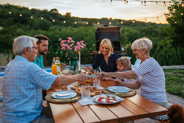 Affectionate family enjoying dinner during their get together in the backyard