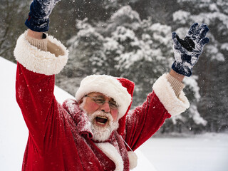 Enthusiasti Santa Claus with raised hands and open mouth on a white snowy background.