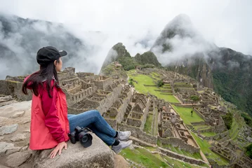 Papier Peint photo Machu Picchu Young Asian woman traveler looking at Machu Picchu, one of seven wonders and famous tourist attraction in Cusco Region of Peru. This majestic place has known as 'Lost City of the Incas'