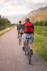 Fototapeta na wymiar Father and son riding ebike and mountainbike on bikeway in Terlan, Southtyrol Italy; healthy active lifestyle concept