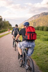 Fototapeta premium Father and son riding ebike and mountainbike on bikeway in Terlan, Southtyrol Italy; healthy active lifestyle concept