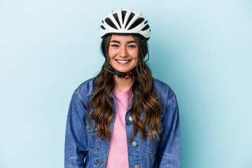 Young caucasian woman rinding a bike isolated on blue background happy, smiling and cheerful.