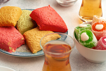 Various Turkish sweets and cup of tea on white textured background