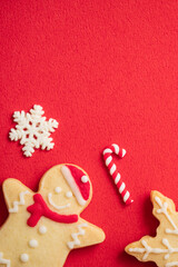 Decorated Christmas gingerbread cookies on red table background.
