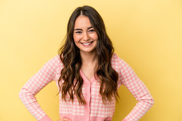 Obraz premium Young caucasian woman isolated on yellow background confident keeping hands on hips.