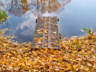 walkway on the lake in yellow foliage in autumn