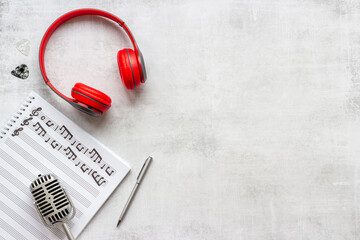 Music sheets with musical notes and headphones, top view