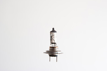 Burned H7 12V 55W halogen car light bulb. Close up studio shot, isolated on white, no people