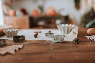 christmas kitchen. wooden table with cooking tools, rolling pin, cupcake and cookie molds. beautifully decorated room for the holiday. space for text. High quality photo