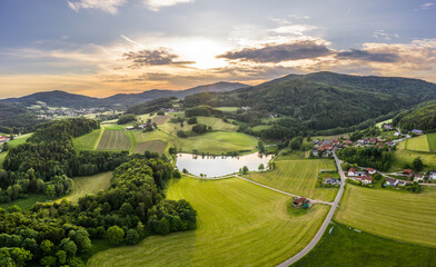 Bild einer Luftaufnahme mit einer Drohne der Landschaft im bayerischen Wald des Ebenreuther See während Sonnenuntergang, Deutschland © stgrafix