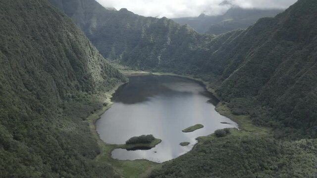 Aerial view of Grande Etang lake among the mountains during a cloudy day, Saint Benoit region, Reunion.
