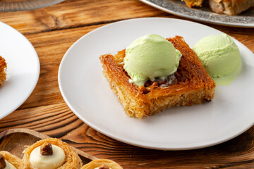 Turkish dessert kunefe served with ice cream on wooden background
