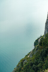 Steil abfallende Felsen und die Straße Gardesana Occidentale am Ufer vom Gardasee in Italien