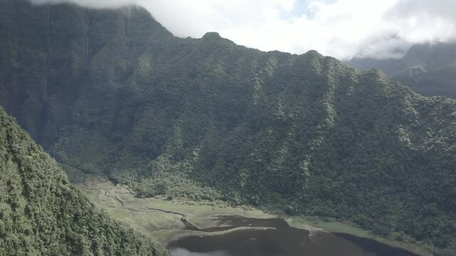 Aerial view of Grande Etang lake among the mountains during a cloudy day, Saint Benoit region, Reunion.