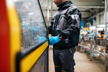 Male worker working in bottling factory. Inspection quality control.