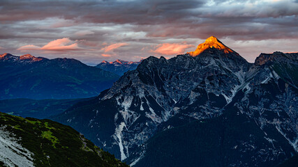 Fototapeta na wymiar An orange peak of Serles mountain from sun during sunset in Stubai alps in Austria.