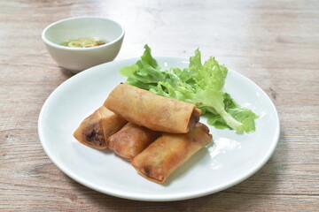 deep fried spring roll stuffed glass noodles with lettuce dipping sweet chili sauce on dish