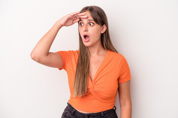 Young caucasian woman isolated on white background looking far away keeping hand on forehead.