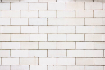 The wall is lined with light beige tiles. Geometric rectangular texture.