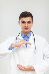 Fototapeta premium The doctor stands forward with a subdued expression and his hands raised.