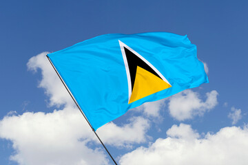 Saint Lucia flag isolated on the blue sky background. close up waving flag of Saint Lucia. flag symbols of Saint Lucia. Concept of Saint Lucia.