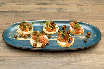 blinis,  tortitas de tradición rusa, polaca y eslava, servidas con salmon ahumado noruego, brotes...