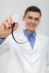 The doctor picks up his stethoscope and positions it directly to the camera. He smiles.
