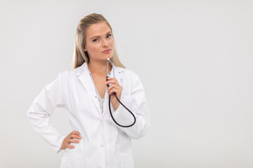 The doctor looks resolutely into the camera and holds a stethoscope in her hand.