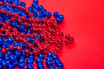 Christmas background. Beads in red and blue on a red background. New Year.
