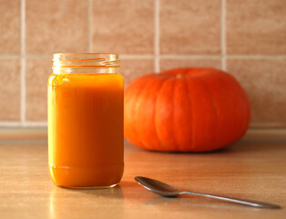 baby pumpkin puree with fresh pumpkin on beige background