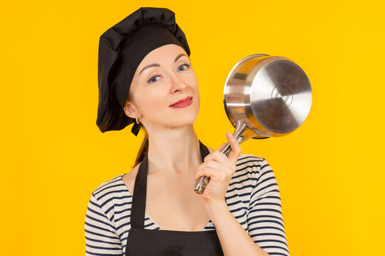 Shef Girl On A Yellow Background. Female Cook Smiles And Stirs