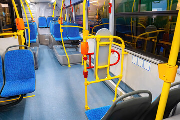 Empty new bus. Transport for carriage of passengers. Regular bus with validators. Interior of modern bus. Municipal transport with contactless payment acceptance. Passenger city transport