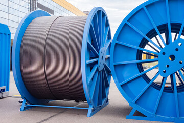 Power cable on reels. Thick electrical wire. Concept - production of power cable. Large spools of...