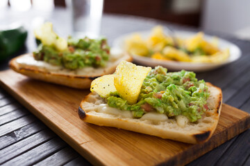toasted slices of square bread with warm cheese and homemade guacamole on plate for healthy breakfast