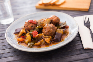 baked meatballs with stewed eggplant, zucchini, green peppers and tomatoes with haze in bowl