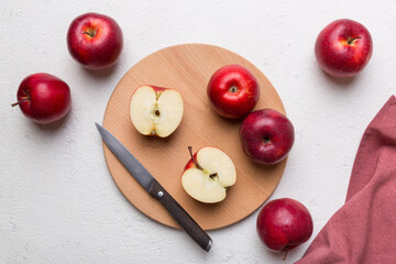 Naklejka na ściany i meble Fresh red apples with green leaves on table. cutting board with knife. Top view