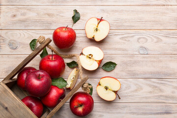 Ripe red apples in wooden box. On a white wooden background