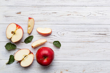 Fresh red apples with green leaves on wooden table. On wooden background. Top view free space for text
