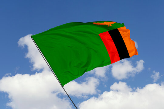 Zambia flag isolated on the blue sky background. close up waving flag of Zambia. flag symbols of Zambia. Concept of Zambia.
