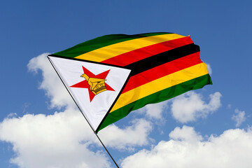 Zimbabwe flag isolated on the blue sky background. close up waving flag of Zimbabwe. flag symbols of Zimbabwe. Concept of Zimbabwe.
