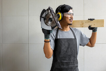 Fototapeta premium Carpenter man holding a circular saw and wood