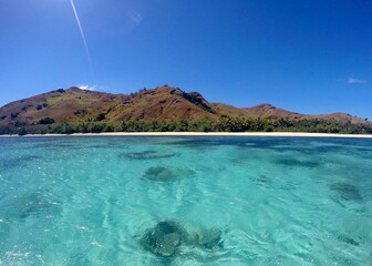 Clear blue water around an island in Fiji