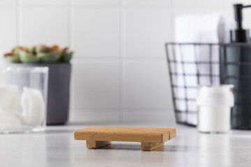 Empty wooden tray and different toiletries set with succulent plant on countertop