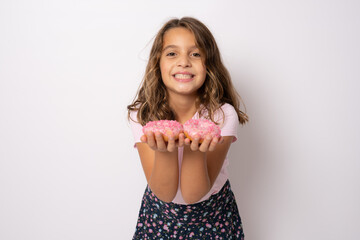 Portrait of a little smiling girl brunette with appetizing donuts in her hands