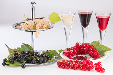 white red and dark black currant with glasses and plates