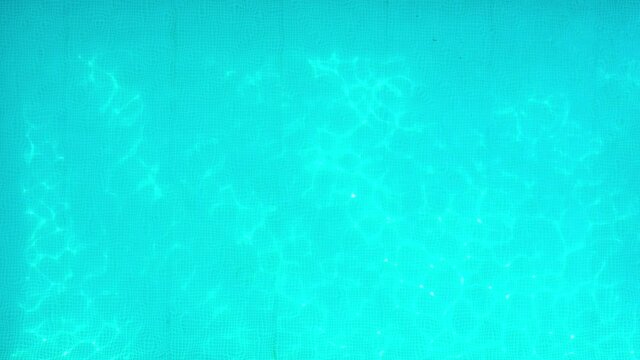 Blue water in the swimming pool with light reflections. Aerial footage